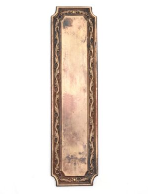 Victorian brass door push plate with an antique brass finish and worn surface, shown vertically with an ornate border and drilled mounting holes.