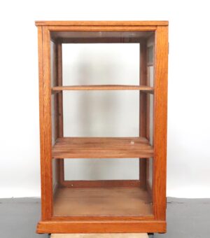 Front view of an oak display cabinet with a glass front and two slatted shelves.