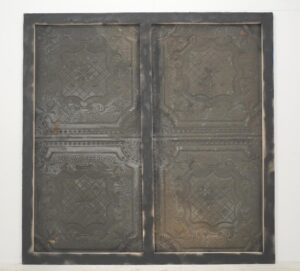 Handcrafted blue tin wall panel with an ornate four-quadrant ceiling pattern in a framed rectangular layout.
