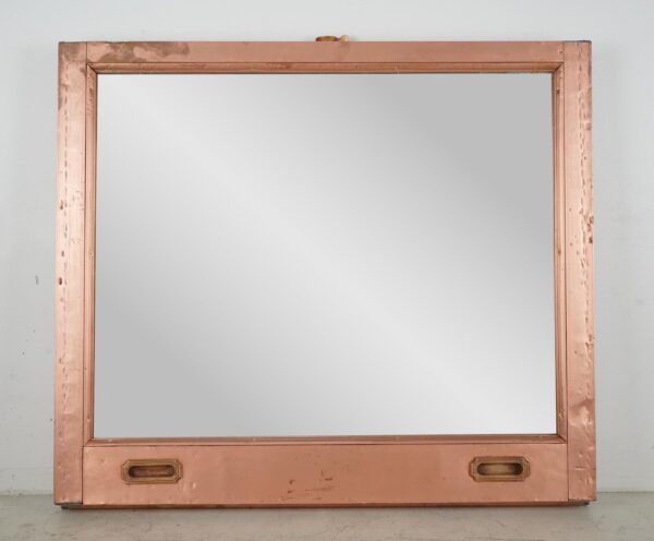 Mirror made from a salvaged copper window frame, shown front view with two recessed handles at the bottom and a mounting wire visible at the top.
