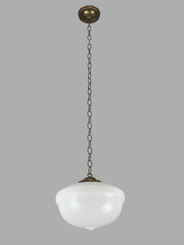 Schoolhouse pendant light with a white milk glass globe and antique brass chain fitter.