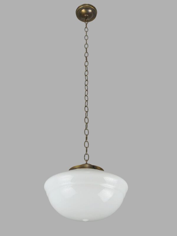 Schoolhouse pendant light with a white milk glass globe and antique brass chain fitter.