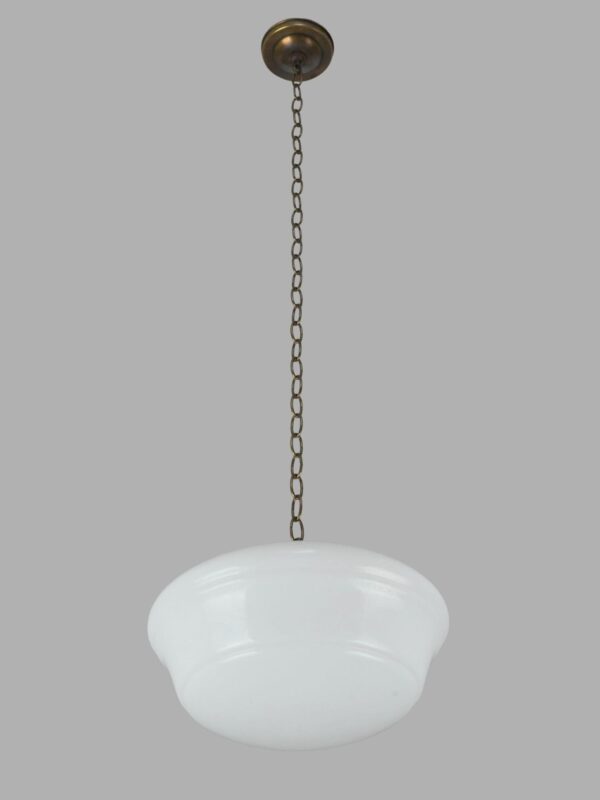 Schoolhouse pendant light with a milk glass globe and antique brass chain fitter.