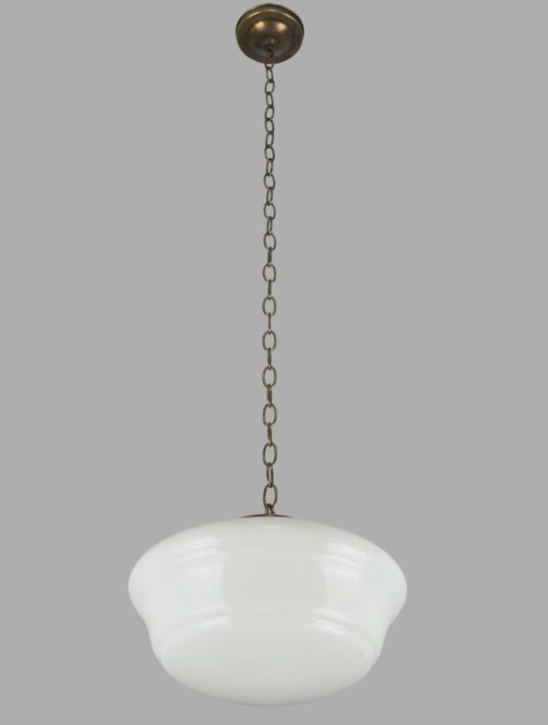 Schoolhouse pendant light with a white milk glass globe and an antique brass chain fitter.