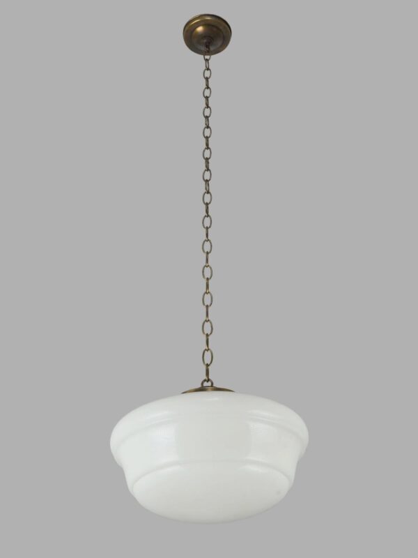 Schoolhouse pendant light with a white milk glass globe and antique brass chain.