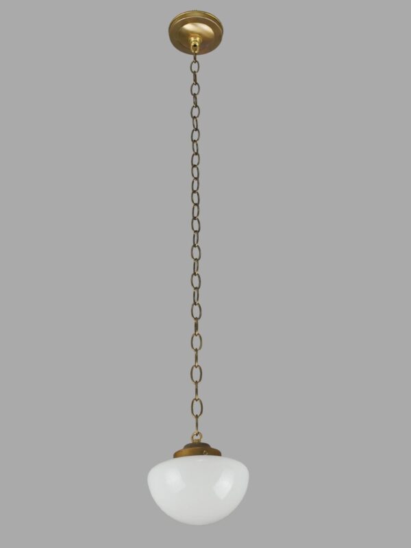 Schoolhouse pendant light with a white milk glass globe and antique brass chain fitter.