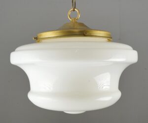 Schoolhouse pendant light with a milk glass globe and antique brass chain fitter.