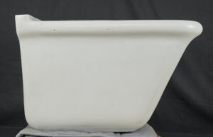 White utility sink basin with a rounded rim and tapered sides, shown from the side with visible surface wear and a few marks.