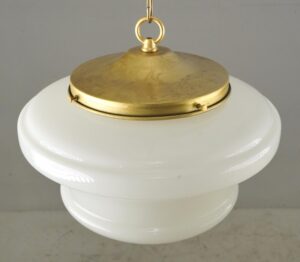 Schoolhouse pendant light with a milk glass globe and antique brass chain fitter.