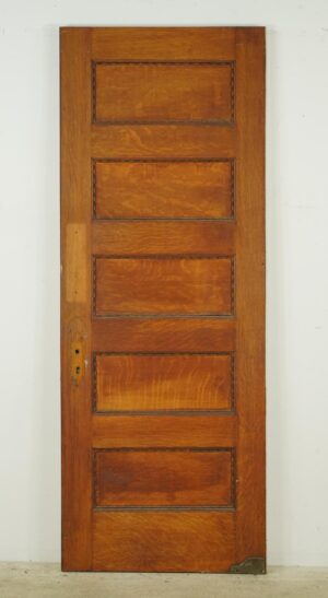 Vintage wooden door with five horizontal panels and a visible lock cutout, shown upright against a plain background.