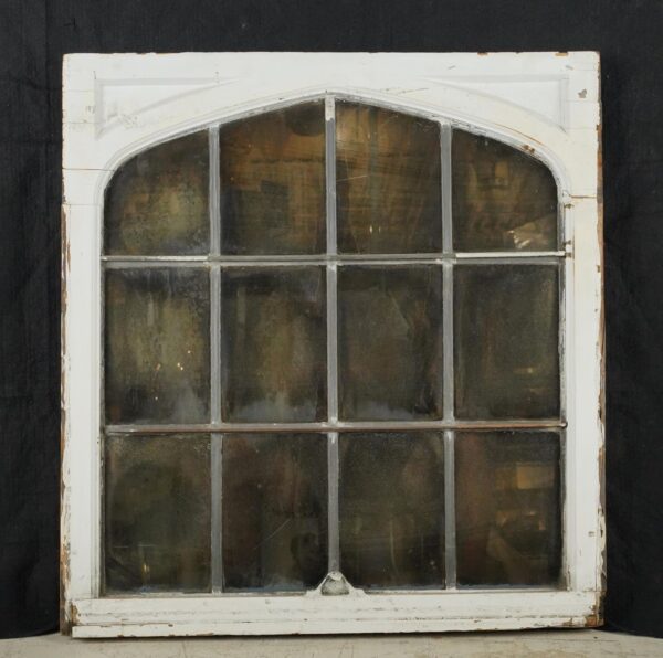 Arched leaded glass window mirror with a white wood frame and worn silvered panes, shown front on with age-related paint wear and a mounting wire attached at the back.