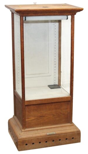 Narrow antique display showcase with glass sides, a medium wood tone oak frame, and vent holes around the base.