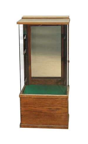Narrow oak and glass display showcase with a mirrored back door, felt-lined deck, and wood base.