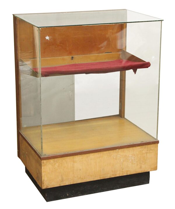 1950s wooden retail showcase with three glass sides, a red velvet shelf, and a lower storage compartment.