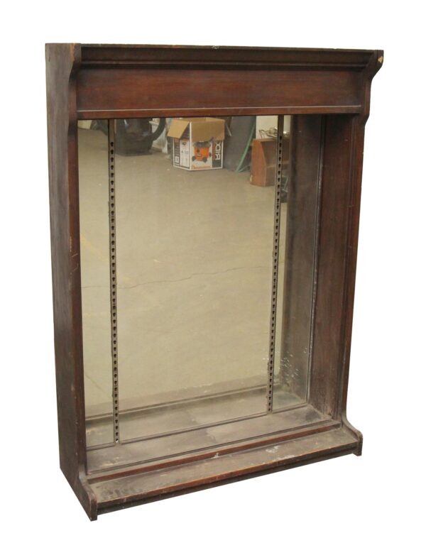 Mirror-backed tabletop showcase in dark wood tones with crown molding style upper trim and built-in shelf tracks, shown without shelves or brackets included.