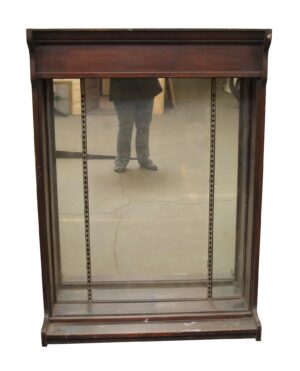 Antique mirror-backed tabletop showcase in dark wood tone with crown molding-style upper trim and adjustable shelf tracks visible inside.