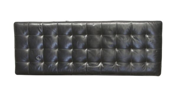 Black tufted leather bench cushion shown from above, with a rectangular shape and visible surface wear.