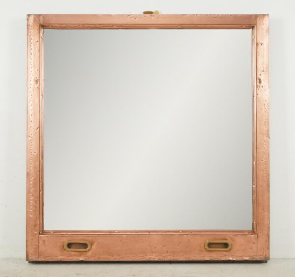 Large mirror made from a copper window frame, with two brass-toned pulls at the bottom and a polished finish.