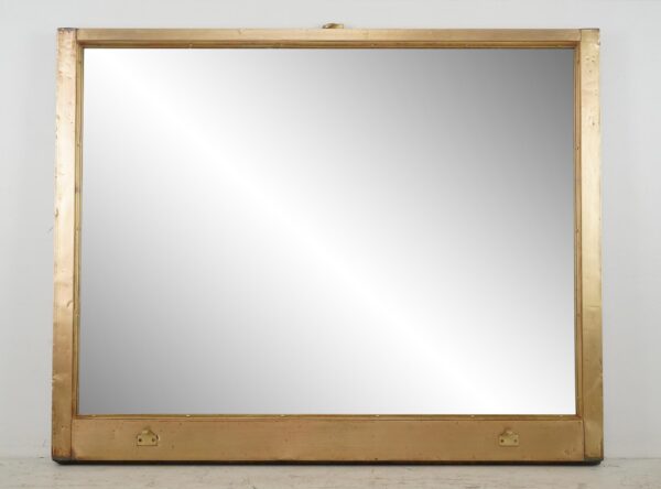 Large mirror in an antique brass window frame with a wide lower panel and mounting wire attached at the top.