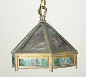Hexagonal pendant light with brass framing, marbled green slag glass panels, and a visible chain connector.