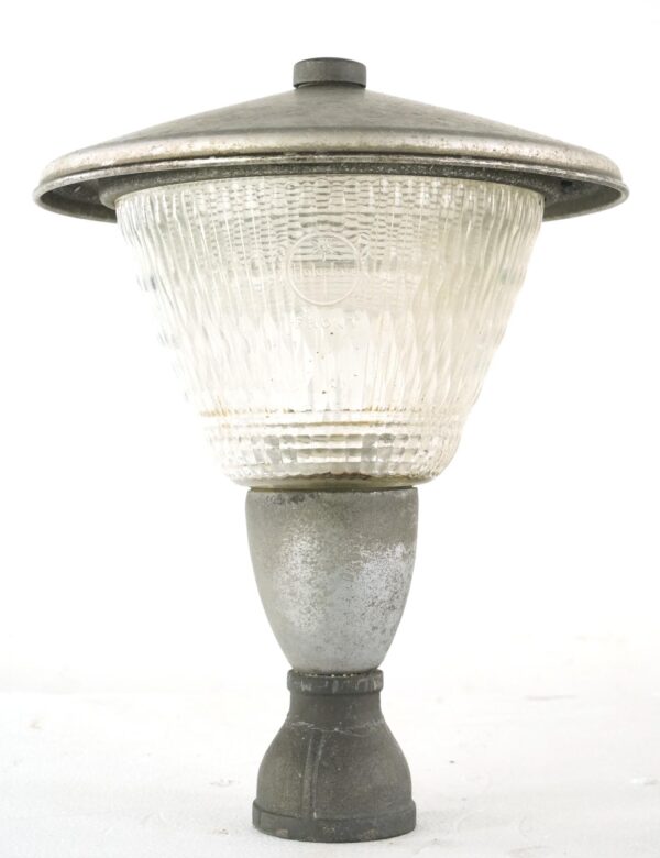 Exterior street lamp post top with clear Holophane glass, a wide brushed steel cap, and a bronze mounting base, shown front view.
