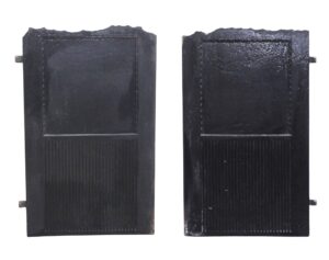 Pair of cast iron fireback doors shown as a matching pair, with beaded Victorian detailing, a jagged top edge, and vertical ribbed lower panels.