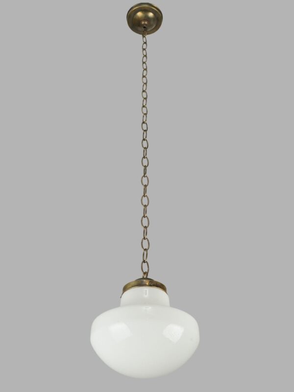 Schoolhouse pendant light with a milk glass globe and antique brass chain fitter.