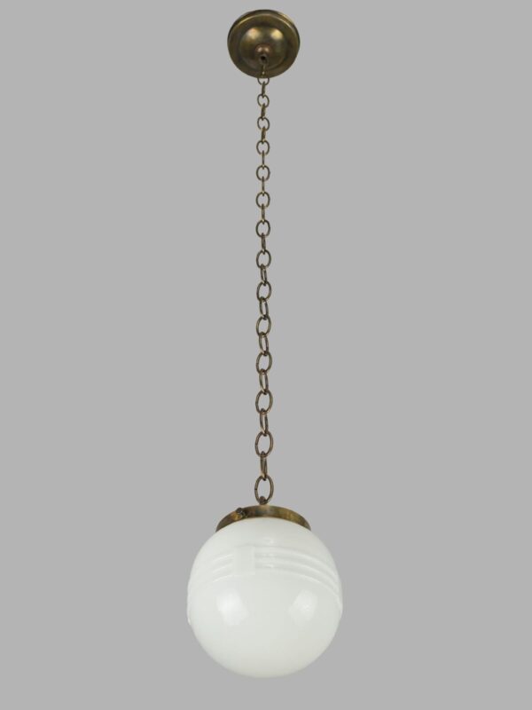 Schoolhouse pendant light with a milk glass globe and antique brass chain fitter.