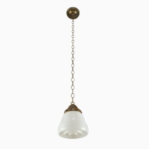 Art Deco pendant light with a milk glass globe, antique brass chain, and Fresnel lens bottom.