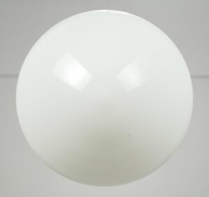 Schoolhouse pendant light with a milk glass globe shown front on, featuring a smooth round shade and faint surface wear.
