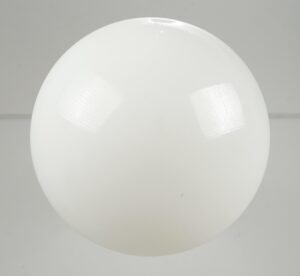 Schoolhouse pendant light with a white milk glass globe shown close up, featuring a smooth round shade and visible surface reflections.