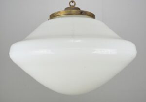 Schoolhouse pendant light with a white milk glass globe and an antique brass chain fitter.