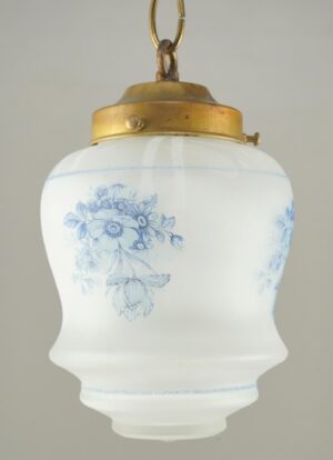 Pendant light with a white and blue floral glass globe and an antique brass chain fitter.