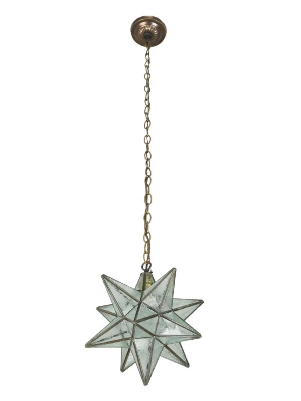 Pendant light with a Moravian star shape, clear textured glass panels, a steel chain, and an antique brass canopy.