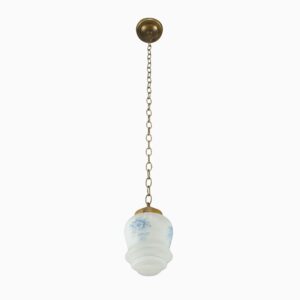 Vintage pendant light with an antique brass chain and a white glass globe with blue floral pattern.