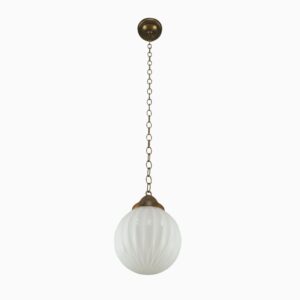 Art Deco pendant light with a ribbed milk glass globe and antique brass chain fitter.