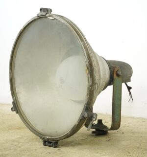 Vintage industrial floodlight with a large round glass lens, brushed aluminum housing, and green mounting bracket shown in side view.