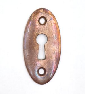 Vintage brass oval keyhole cover plate with two screw holes and a central keyhole opening.