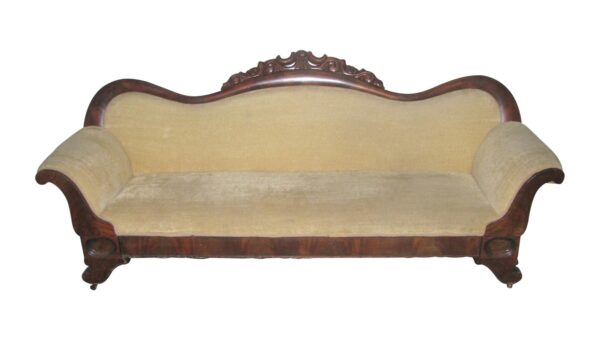 Victorian-style sofa with a curved carved wood back, rounded arms, and tan velvet upholstery.