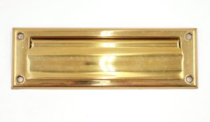 Polished brass rectangular mail slot with four corner screw holes and a spring-loaded flap.