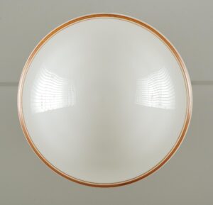 Art Deco milk glass pendant light with a round white globe and brown striping around the rim.