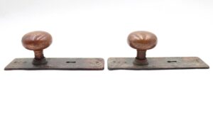 Pair of antique brass dummy door knobs with round knobs on rectangular back plates, shown side by side with visible surface wear.