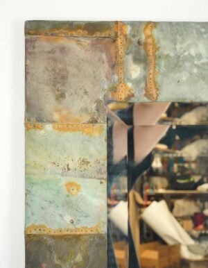Handcrafted dressing mirror with a patchwork copper frame and beveled mirror surface, shown in a close-up of the corner and edge details.