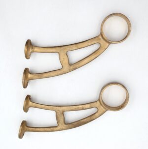 Pair of reclaimed brass bar mount brackets shown as a pair, each with a circular mounting ring and two support arms with surface wear.