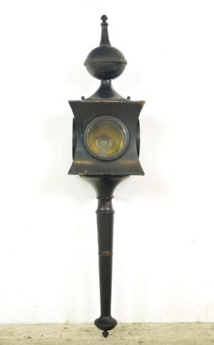 Hard-wired carriage lamp sconce with a black finish, shown in full length with a clear glass lens and tapered mounting arm.