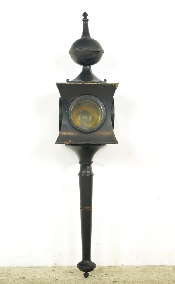Hard-wired carriage lamp sconce with a black finish, shown in full length with a clear glass lens and tapered mounting arm.