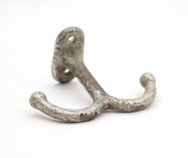 Cast iron double ceiling mount hook with two curved arms and a worn silver-painted finish, shown in a close-up view.