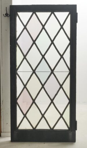 Tudor-style casement window with a leaded diamond pattern, black-painted steel frame, and visible hinges.