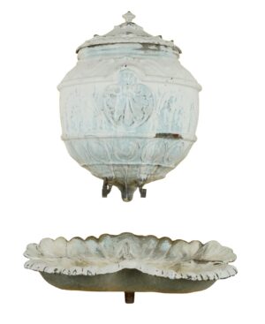 French-style enameled cast iron wall fountain shown as two pieces, with a lidded upper reservoir and a scallop-shaped lower basin in pale blue and white with visible wear.