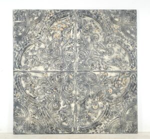 Square gray tin wall panel with an ornate four-quadrant embossed floral pattern and a centered cross seam.